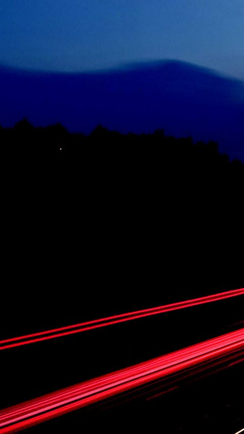 long exposed image of highway at night with red and yellow lines 